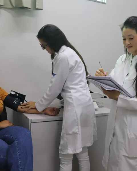 Acadêmicas aferindo a pressão de paciente em atendimento supervisionado